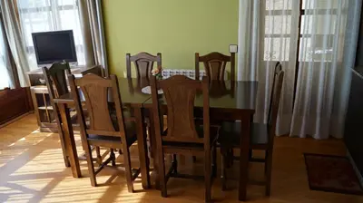 a dining room with a table and chairs and a television at La Artesana in Posada de Rengos