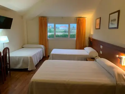 a hotel room with two beds and a window at Hotel Barreiro in Leira
