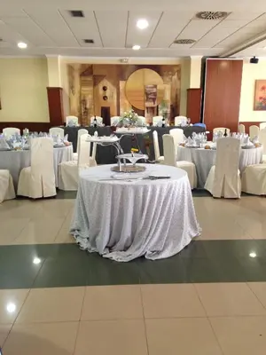 a banquet hall with white tables and white chairs at Hotel Barreiro in Leira