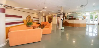 a hospital lobby with orange chairs and a counter at Hotel Barreiro in Leira