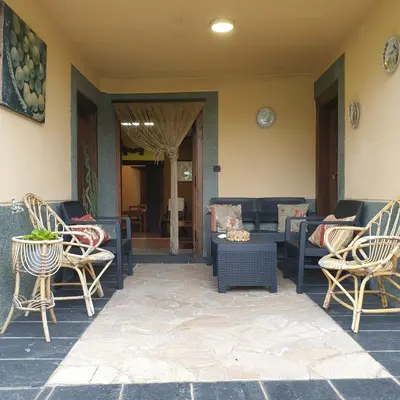 a patio with chairs and a couch and a table at VV La Pumarada De Limés II in Cangas del Narcea