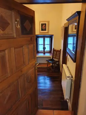 a hallway with a wooden door and a chair at VV La Pumarada De Limés II in Cangas del Narcea