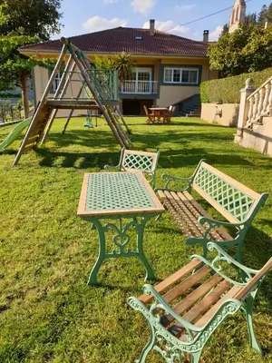 two park benches and a table and a playground at VV La Pumarada De Limés II in Cangas del Narcea