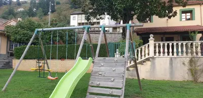 a playground with a green slide in a yard at VV La Pumarada De Limés II in Cangas del Narcea