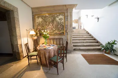 a dining room with a table and a painting on the wall at Pazo de Sedor in Arzúa