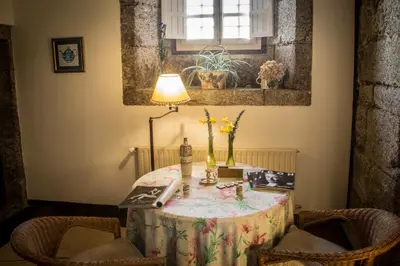 a table in a room with a lamp and chairs at Pazo de Sedor in Arzúa