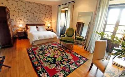 a bedroom with a bed and a rug on the floor at Rectoral de Cines in Oza dos Ríos