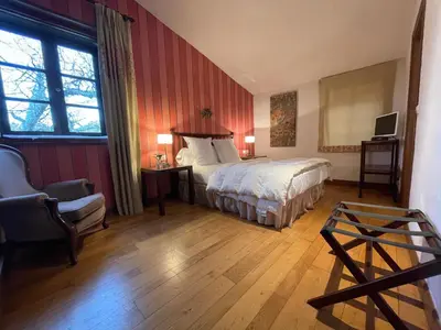 a hotel room with a bed and a chair at Rectoral de Cines in Oza dos Ríos