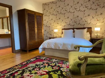 a bedroom with a bed and a chair and a rug at Rectoral de Cines in Oza dos Ríos