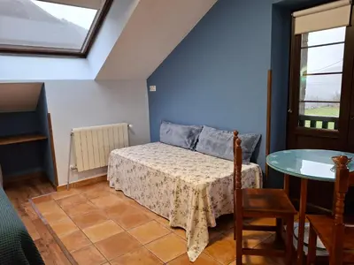 a small bedroom with a bed and a table at La Corona del Auteiro in Valle de Lago