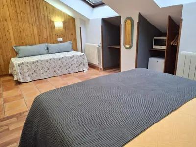 a bedroom with two beds in a room at La Corona del Auteiro in Valle de Lago