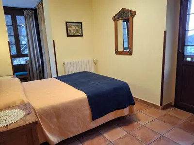 a bedroom with a bed and a mirror on the wall at La Corona del Auteiro in Valle de Lago