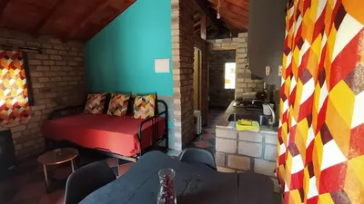 a living room with a bed and a kitchen at cabañas bungalow albergue camping valle do seo in Trabadelo