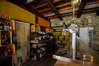 a bar with a counter in a room at cabañas bungalow albergue camping valle do seo in Trabadelo