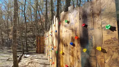 a group of people on a climbing wall at cabañas bungalow albergue camping valle do seo in Trabadelo