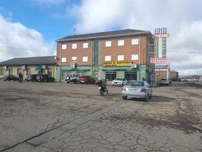 a man on a motorcycle parked in front of a building at Hostal Residencia Delfin in Astorga