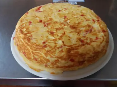 a cheese pizza sitting on a plate on a table at Hostal Residencia Delfin in Astorga
