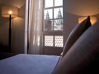 a bedroom with a bed and a window at Carris Casa de la Troya in Santiago de Compostela
