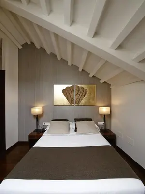 a bedroom with a large white bed with two lamps at Carris Casa de la Troya in Santiago de Compostela