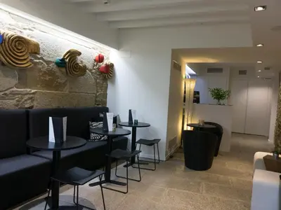 a restaurant with two tables and chairs and a wall at Carris Casa de la Troya in Santiago de Compostela