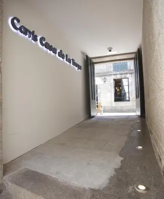 a hallway with a white wall with a sign on it at Carris Casa de la Troya in Santiago de Compostela