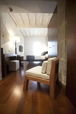 a living room with a bed and a room with a couch at Carris Casa de la Troya in Santiago de Compostela