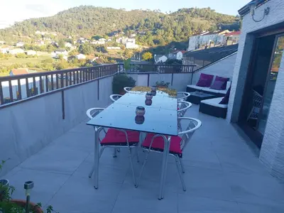 a table with two chairs on a balcony at Duplex grandes cristaleras impresionantes vistas in Ourense