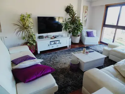 a living room with white furniture and purple pillows at Duplex grandes cristaleras impresionantes vistas in Ourense