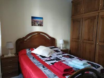 a bedroom with a bed with a wooden head board at PRECIOSA CASA DE 4 HABITACIONES EN PLENO CORAZÓN DEL CAMINO DE SANTIAGO! in Palas de Rei
