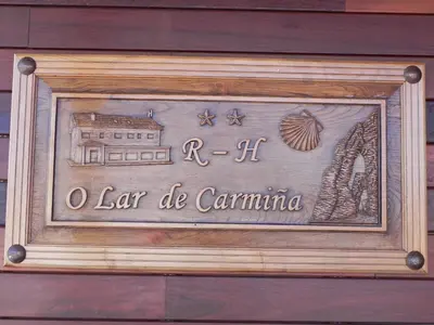 a sign on a building that says la carolina at O Lar de Carmiña in Devesa