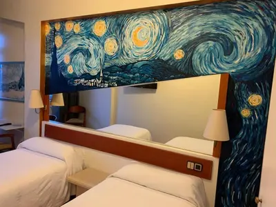 a painting above two beds in a hotel room at Hotel Brial in Perillo