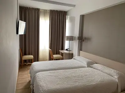 a hotel room with a bed and a desk at Hotel Brial in Perillo