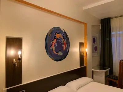 a bedroom with a bed and a plate on the wall at Hotel Brial in Perillo