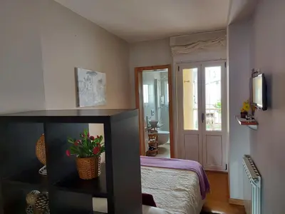 a bedroom with a bed and a door to a bathroom at Ultreia in Portomarin