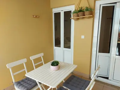 a white table and chairs with a potted plant on it at Ultreia in Portomarin