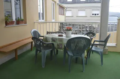 a room with a table and chairs on a balcony at Ultreia in Portomarin