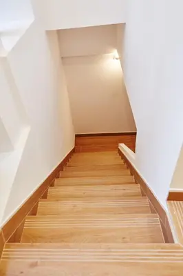 a staircase in a room with wooden floors and white walls at Apartamentos Orfas in Santiago de Compostela