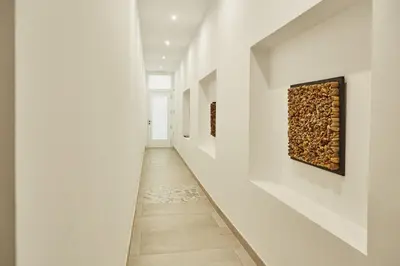 an empty hallway with white walls and a painting on the wall at Apartamentos Orfas in Santiago de Compostela