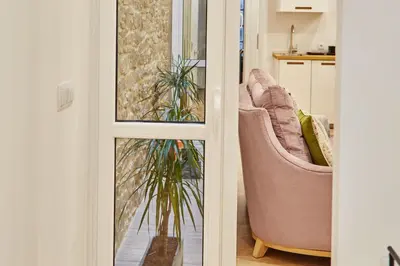 a living room with two chairs and a plant at Apartamentos Orfas in Santiago de Compostela