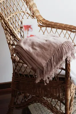 a wicker chair with a blanket on it at 