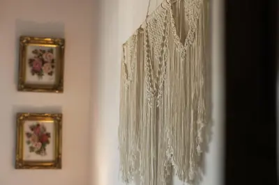 a white lace curtain on a wall with two pictures at 