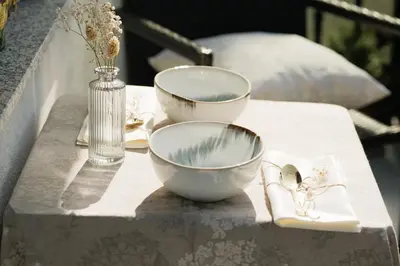 a table with two bowls and a vase on it at 