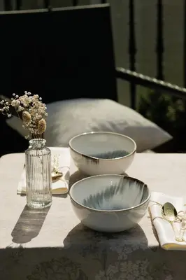 a table with two bowls and a vase with flowers at 