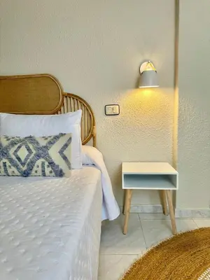 a bedroom with a bed and a nightstand with a side table at Apartamentos Sarga Sentirgalicia in Cabañas