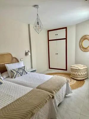 a large bedroom with two beds and a door at Apartamentos Sarga Sentirgalicia in Cabañas