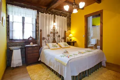 a bedroom with a large bed with yellow walls at Casa Ponce in Posada de Rengos