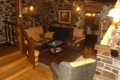 a living room with couches and a stone wall at Casa Ponce in Posada de Rengos