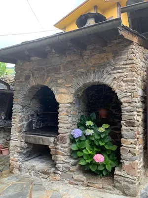 a stone oven with flowers in a garden at Casa Ponce in Posada de Rengos