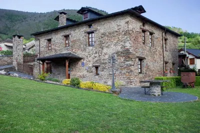 a large stone building with a table in front of it at Casa Ponce in Posada de Rengos