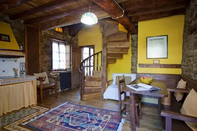 a kitchen and living room with yellow walls and a table at Casa Ponce in Posada de Rengos